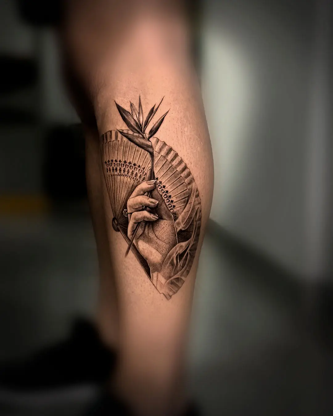 Mano con abanico y ave del paraíso